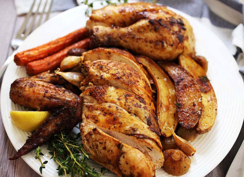 Roasted sliced chicken on plate with vegetables. 