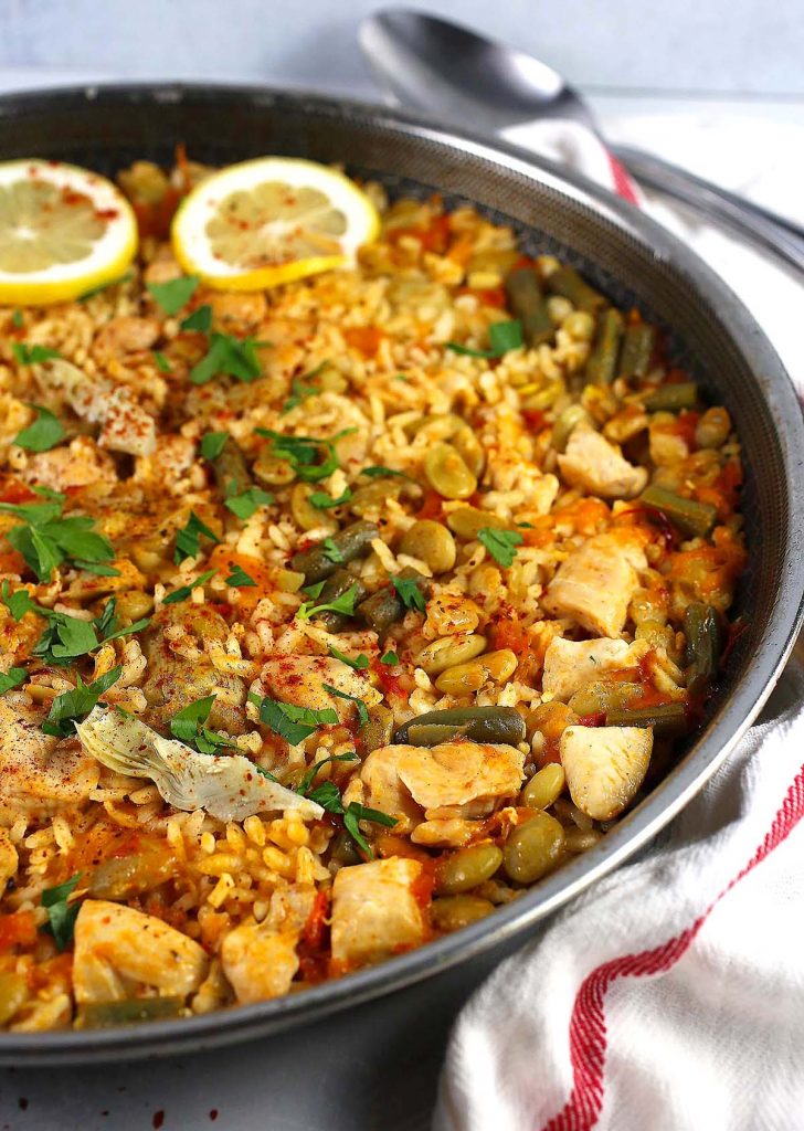 Valencian paella with chicken and in pan.