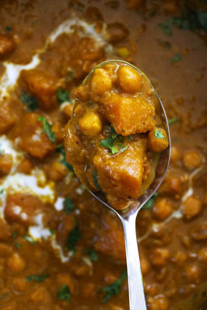 Pumpkin spice curry with chickpeas and coconut cream in pan.