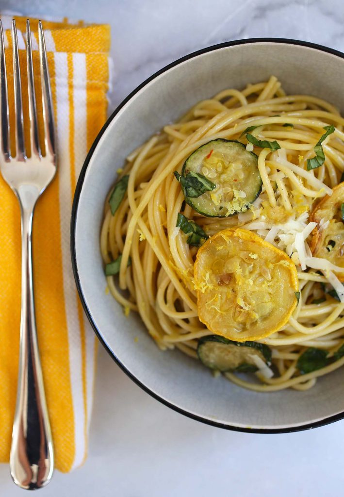 spaghetti with zucchini and basil in plate.