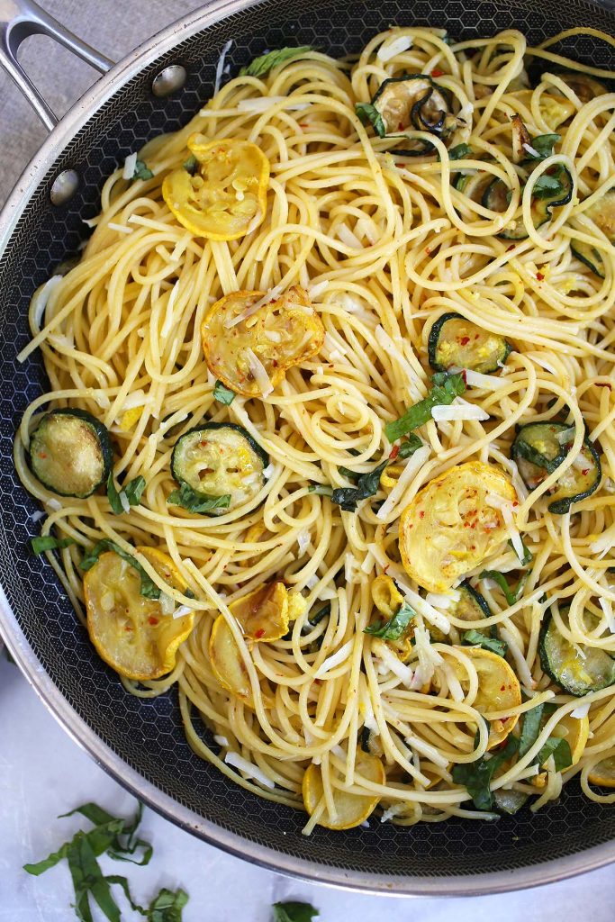 spaghetti with zucchini and lemon zest in pan.