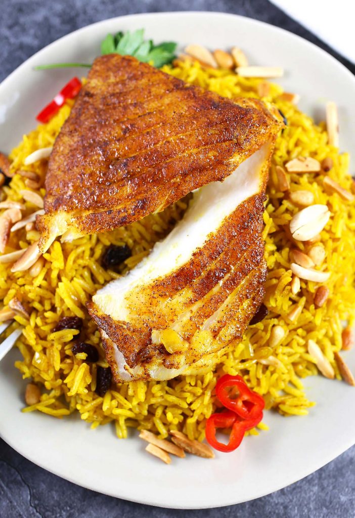 Basmati rice with spiced fish on plate.