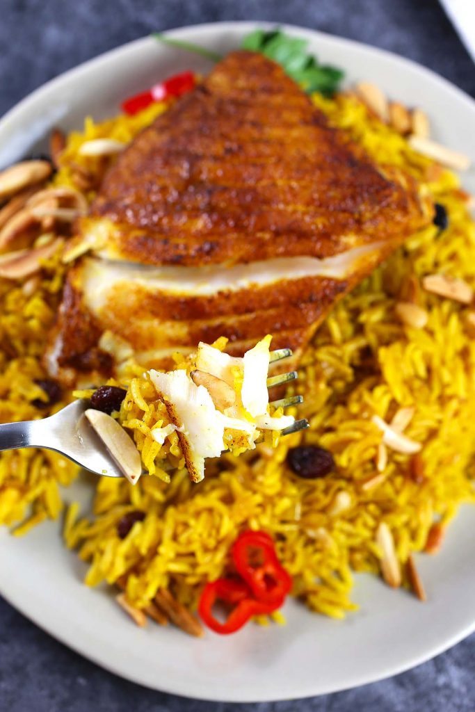 Basmati rice with spiced fish on plate.