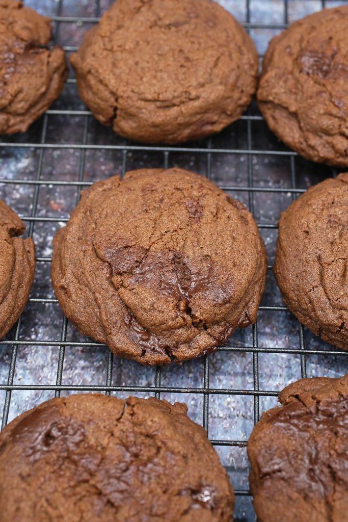 Dark chocolate cookies cooling on rack.