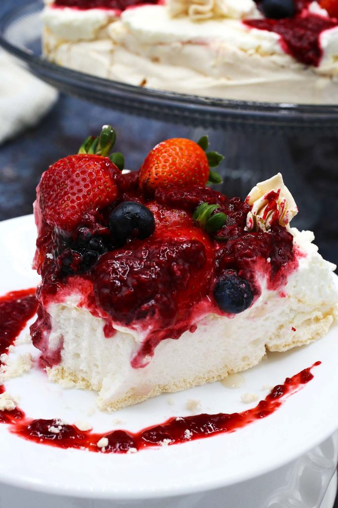 Slice of pavlova with cream and fresh berries.