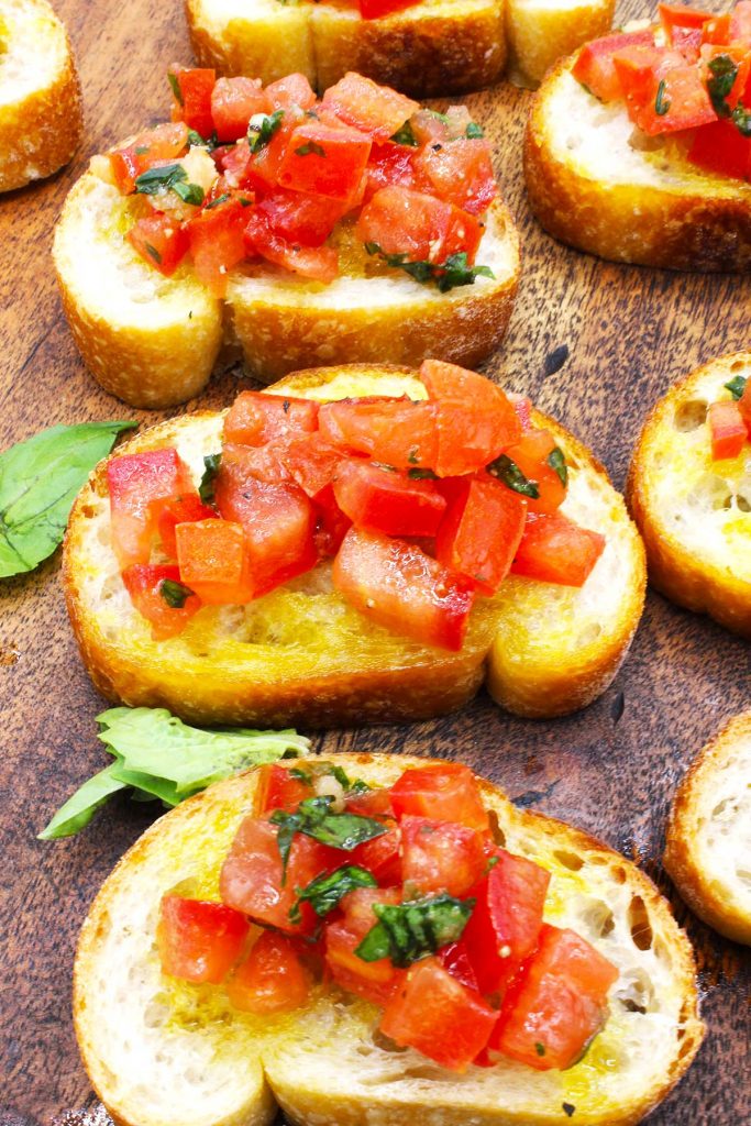 Bread slices with tomato,basil and olive oil on top.