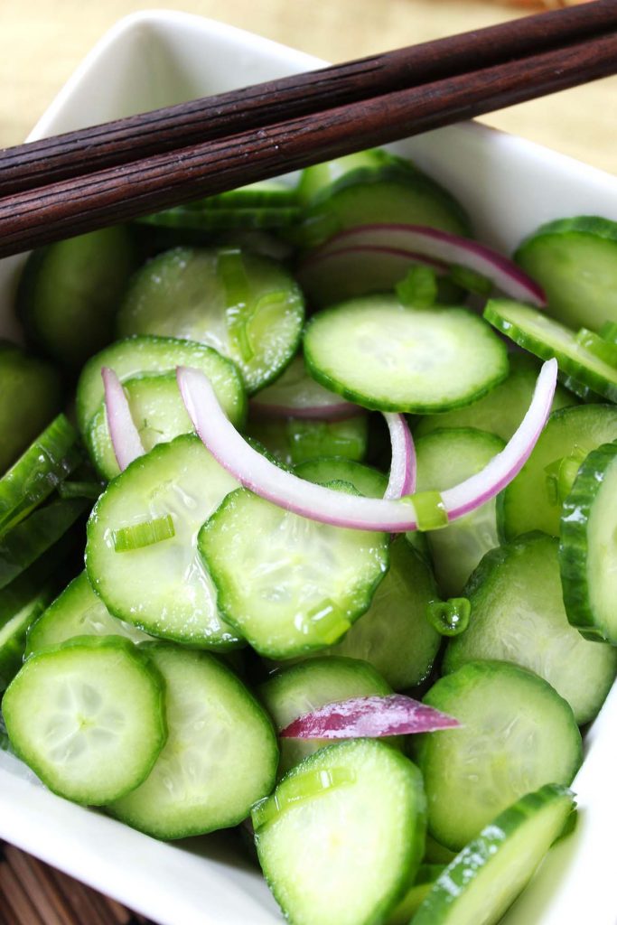 Cucumber salad serving in small plate with chopsticks. 