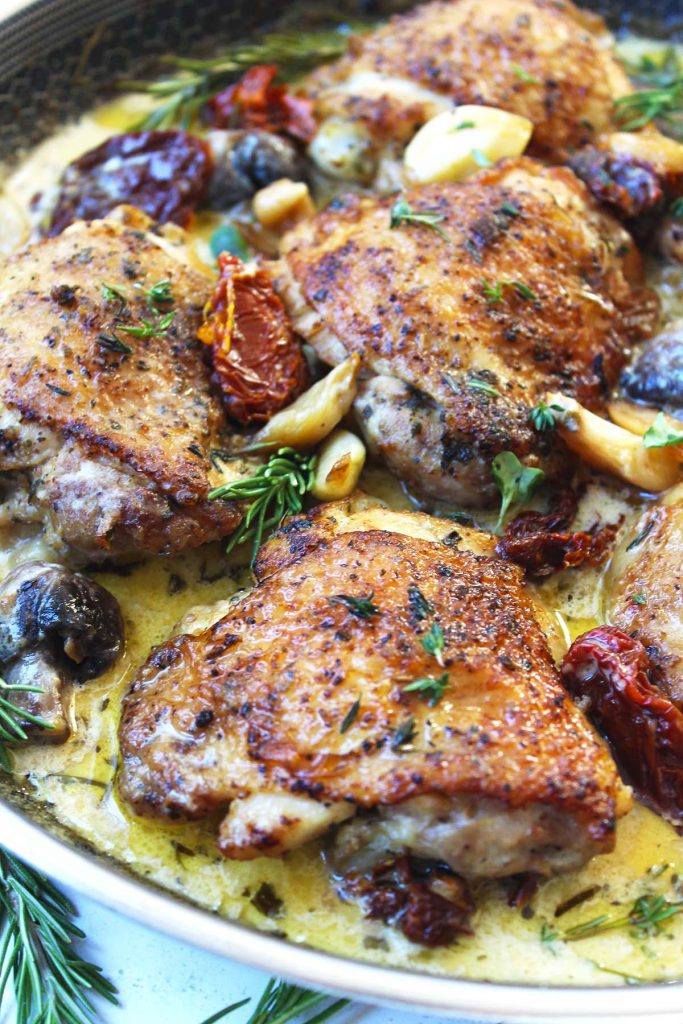 Chicken in pan with mushrooms, herbs and sun dried tomato. 