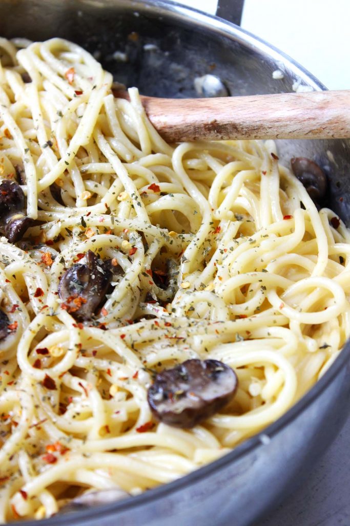 Pasta with mushrooms and chili flakes on top.